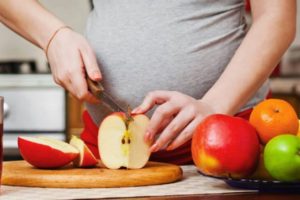 gestante cortando frutas durante a gravidez