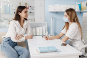 médica atendendo paciente na clínica sim e explicando sobre câncer de colo do útero