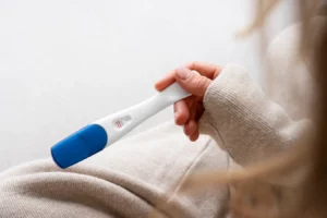Teste de gravidez em mãos femininas, simbolizando a expectativa e a alegria de uma nova vida. Consulta sobre gravidez e saúde maternal.