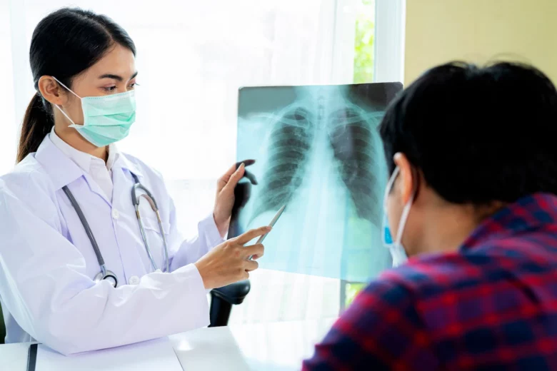 Médica analisa raio-x de pulmão com paciente, discutindo sintomas e diagnóstico de pneumonia.