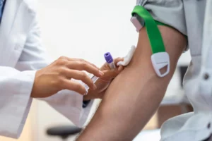 Profissional de saúde realiza coleta de sangue para exames de sangue básicos em paciente, com materiais esterilizados em ambiente clínico.
