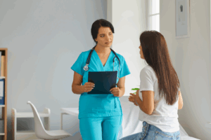 Profissional de saúde em uma clínica popular oferece atendimento atencioso a uma paciente, mostrando a qualidade e acessibilidade dos serviços médicos locais.